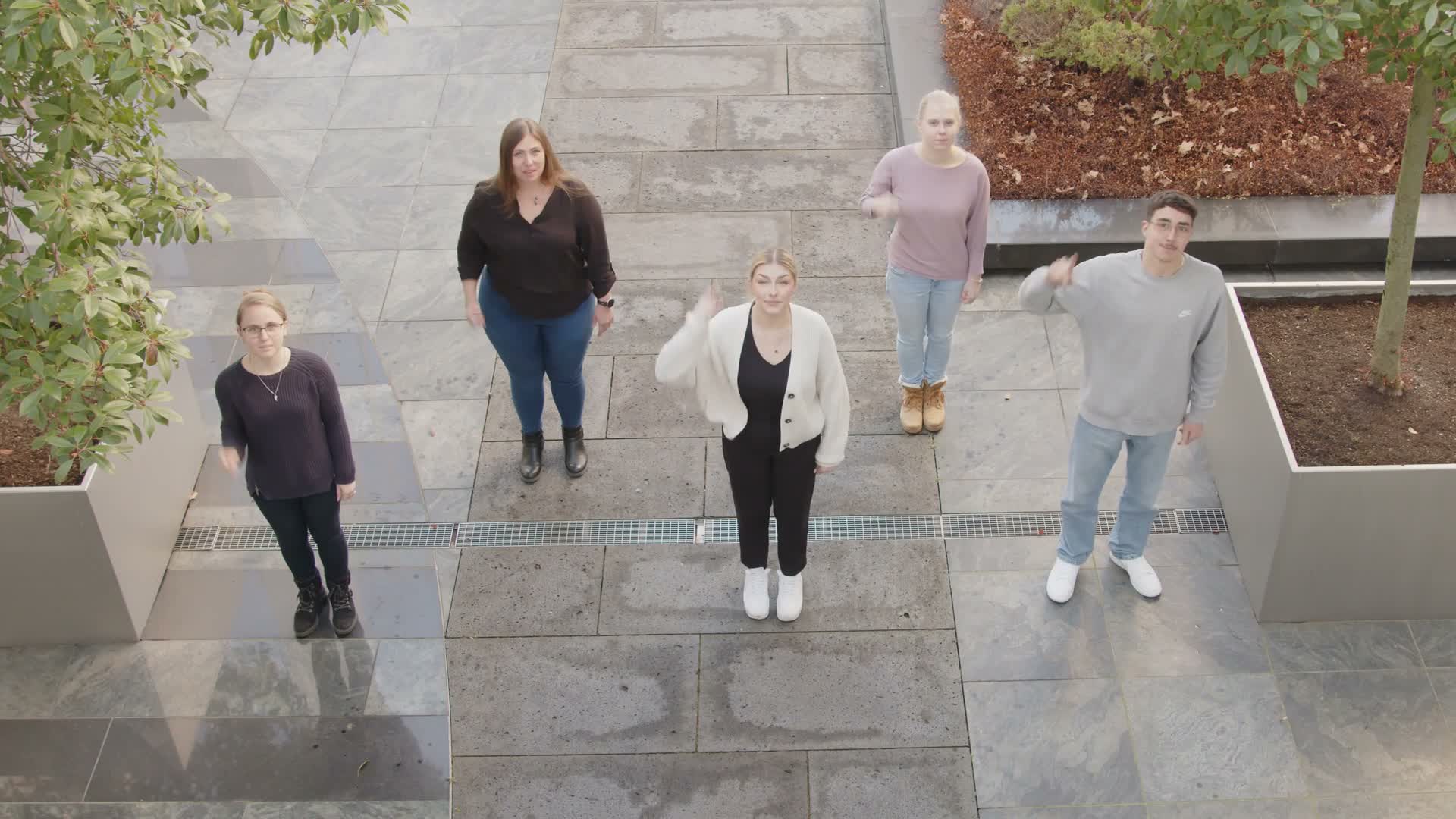 Fünf Personen aus dem ARWA Azubi-Video 2023 auf einer Außentreppe