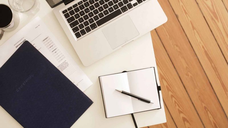 Arbeitsplatz mit Laptop, Notizbuch, Stift und Unterlagen - persÃ¶nliche Kompetenzen im Lebenslauf