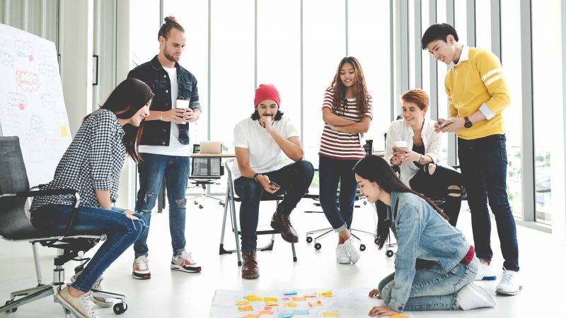 Teamgeist stÃ¤rken: Gruppe junger Kollegen bei einer kreativen Team-Building-Session im BÃ¼ro.