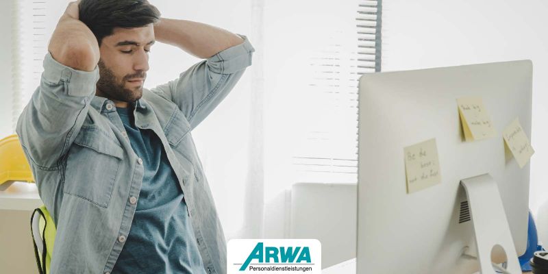 Mann sitzt nachdenklich vor einem Computer in einem Büro, symbolisiert Unzufriedenheit oder Frustration am Arbeitsplatz.