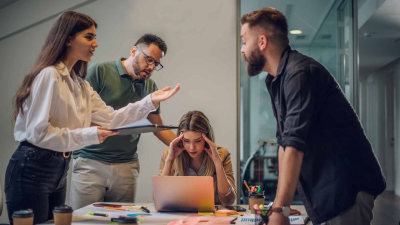 Vier Personen in einer angespannten Diskussion im BÃ¼ro â€“ symbolisiert Konflikte und die Bedeutung von KonfliktfÃ¤higkeit im Team.