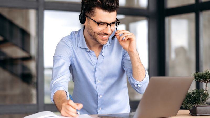 Mann mit Headset bei der Arbeit am Laptop als Beispiel fÃ¼r persÃ¶nliche Kompetenzen.