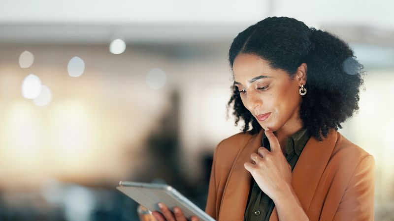 Nachdenkliche Frau mit Tablet als Symbol fÃ¼r persÃ¶nliche Weiterentwicklung.