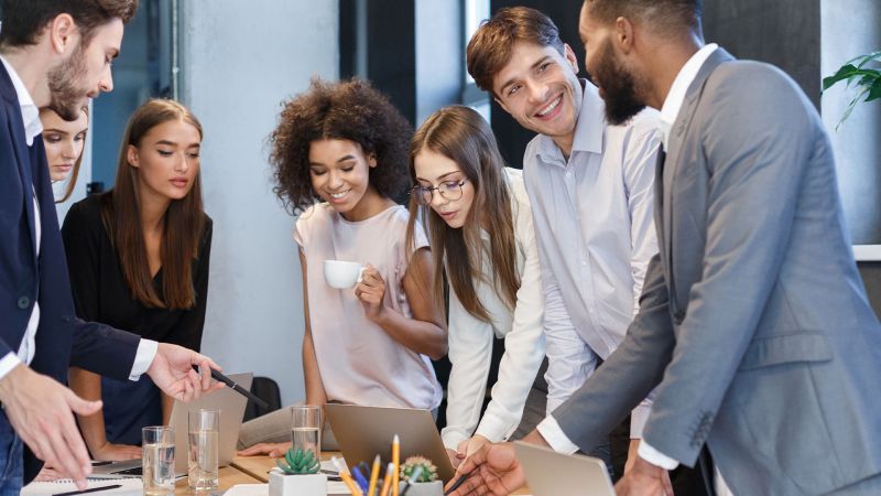 Junge, diverse Teammitglieder bei einer Besprechung â€“ symbolisiert die Zusammenarbeit und Werteorientierung der Generation Y.