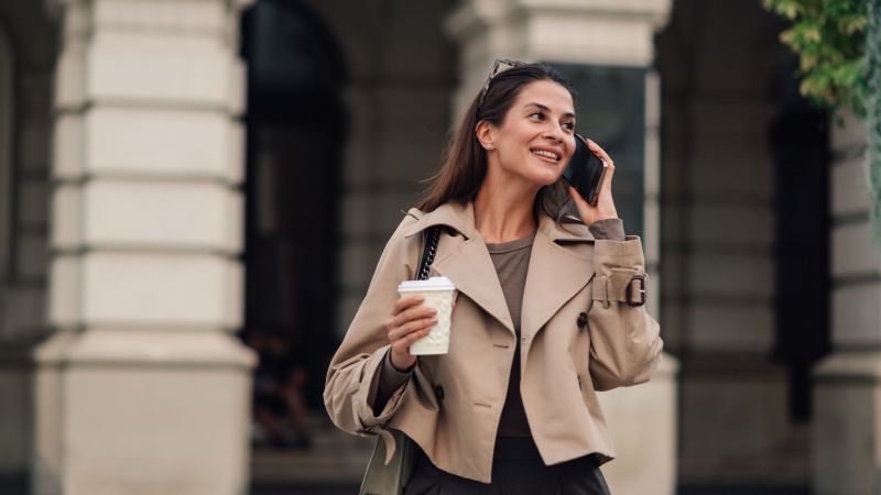 Junge Frau mit Kaffeebecher und Smartphone â€“ symbolisiert die FlexibilitÃ¤t und TechnologieaffinitÃ¤t der Generation Y.